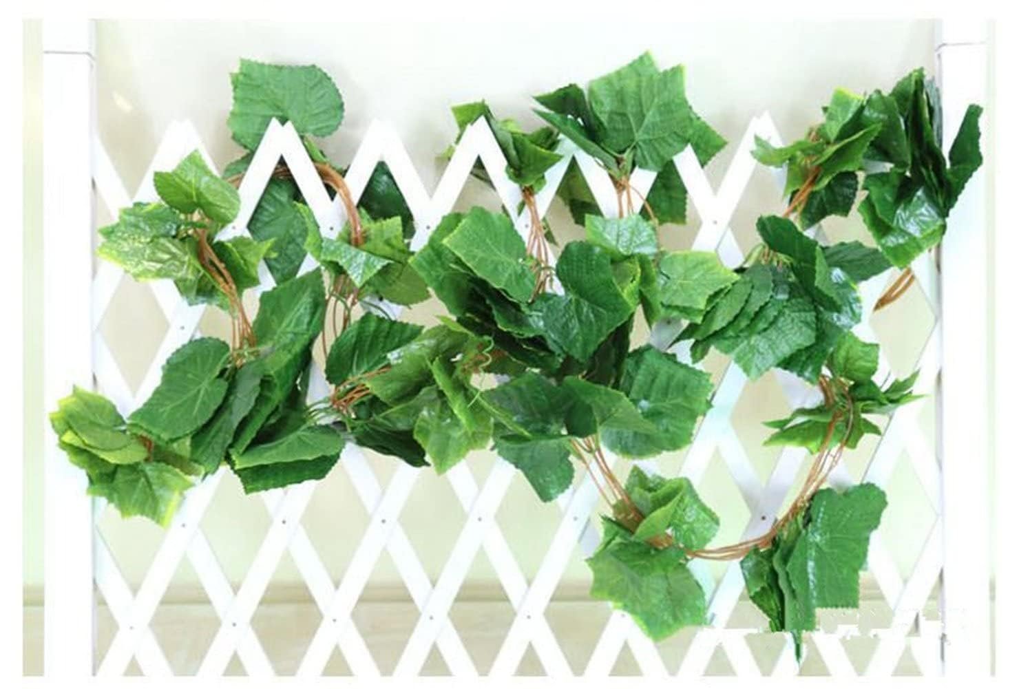 Artificial grape ivy vine garland with green silk leaves draped over a white lattice fence