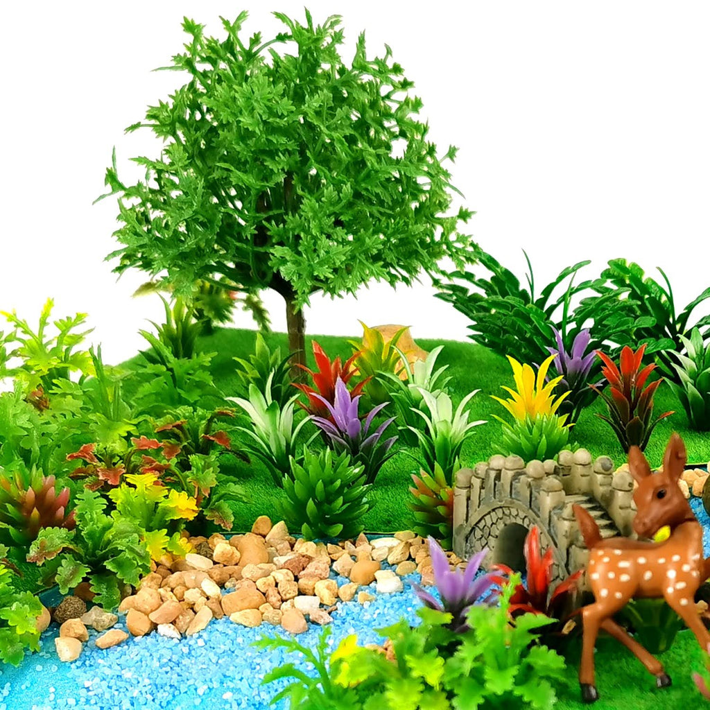 Miniature model trees and plants with a deer and bridge, arranged in a diorama setting.