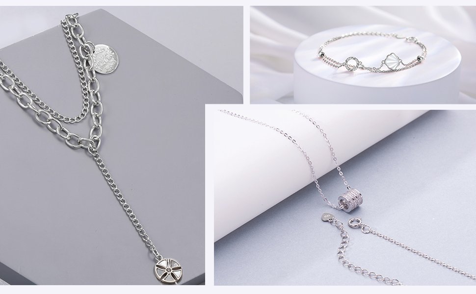 Collage of silver necklaces and bracelets, one layered necklace with charms, one bracelet with shell and circle charms, and one pendant necklace with a jeweled cylinder.