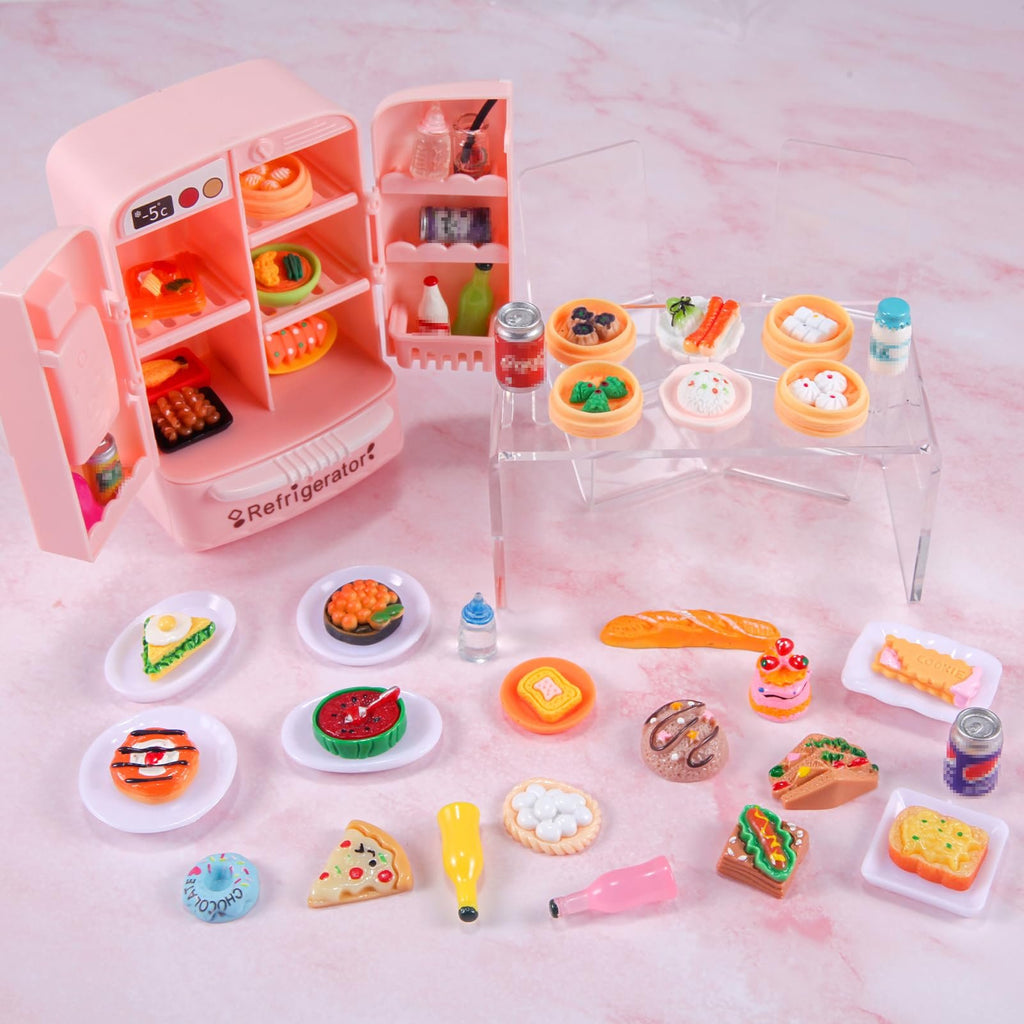 Pink dollhouse refrigerator with miniature food items and accessories arranged around it on a pink marble background.