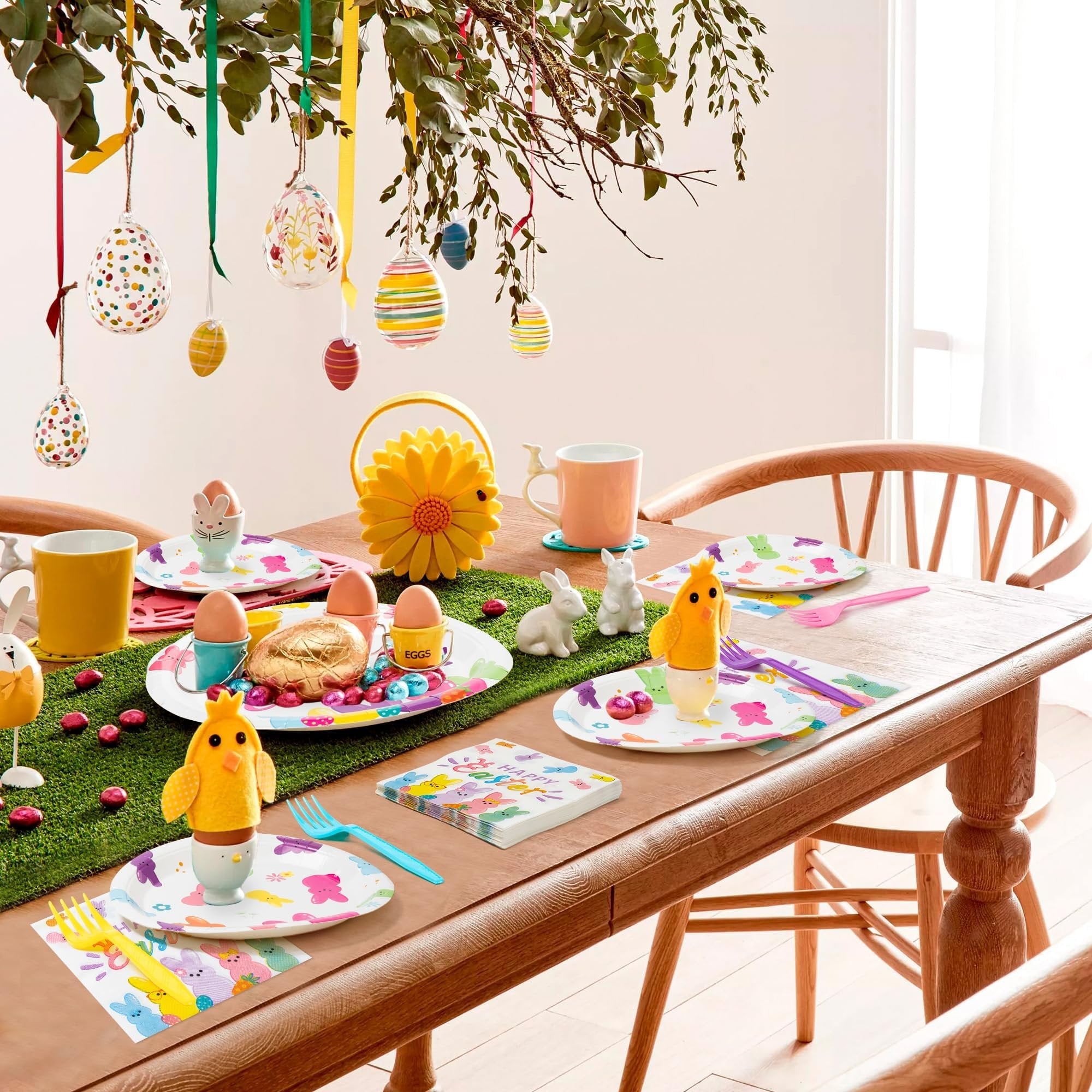 Easter table setting with plates, napkins, forks, egg cups, and decorative bunnies and chicks.