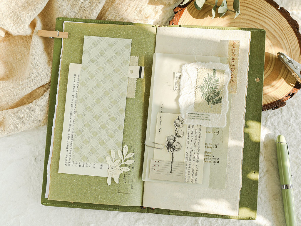 Open journal with textured green paper, decorative paper, fabric swatch, and botanical illustrations.