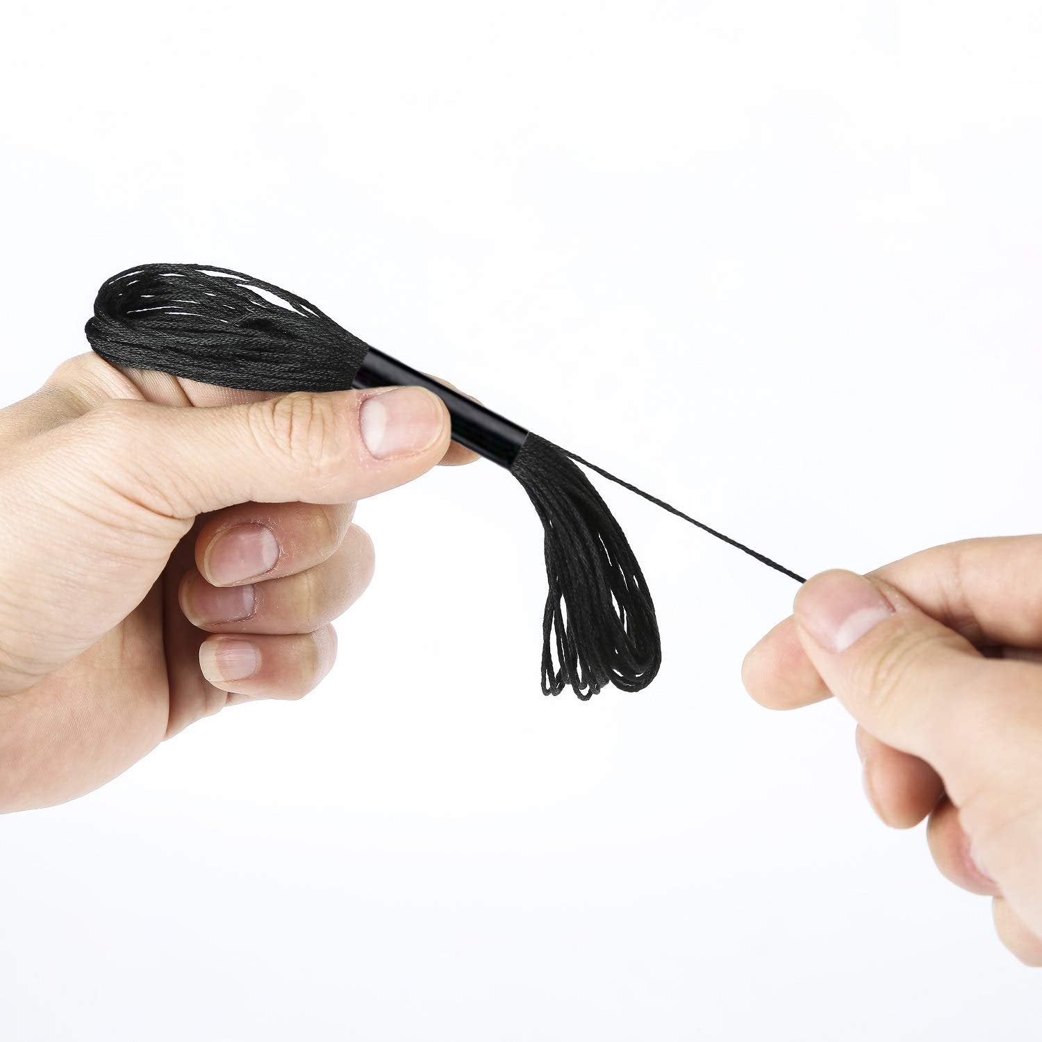 Hands holding a skein of black embroidery floss, one hand unwinding the thread.
