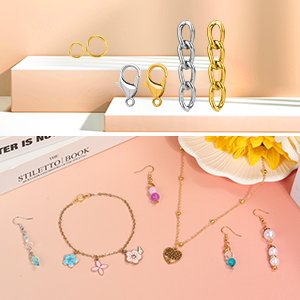 Keychain making kit components and finished jewelry pieces displayed on a pink surface with decorative elements.