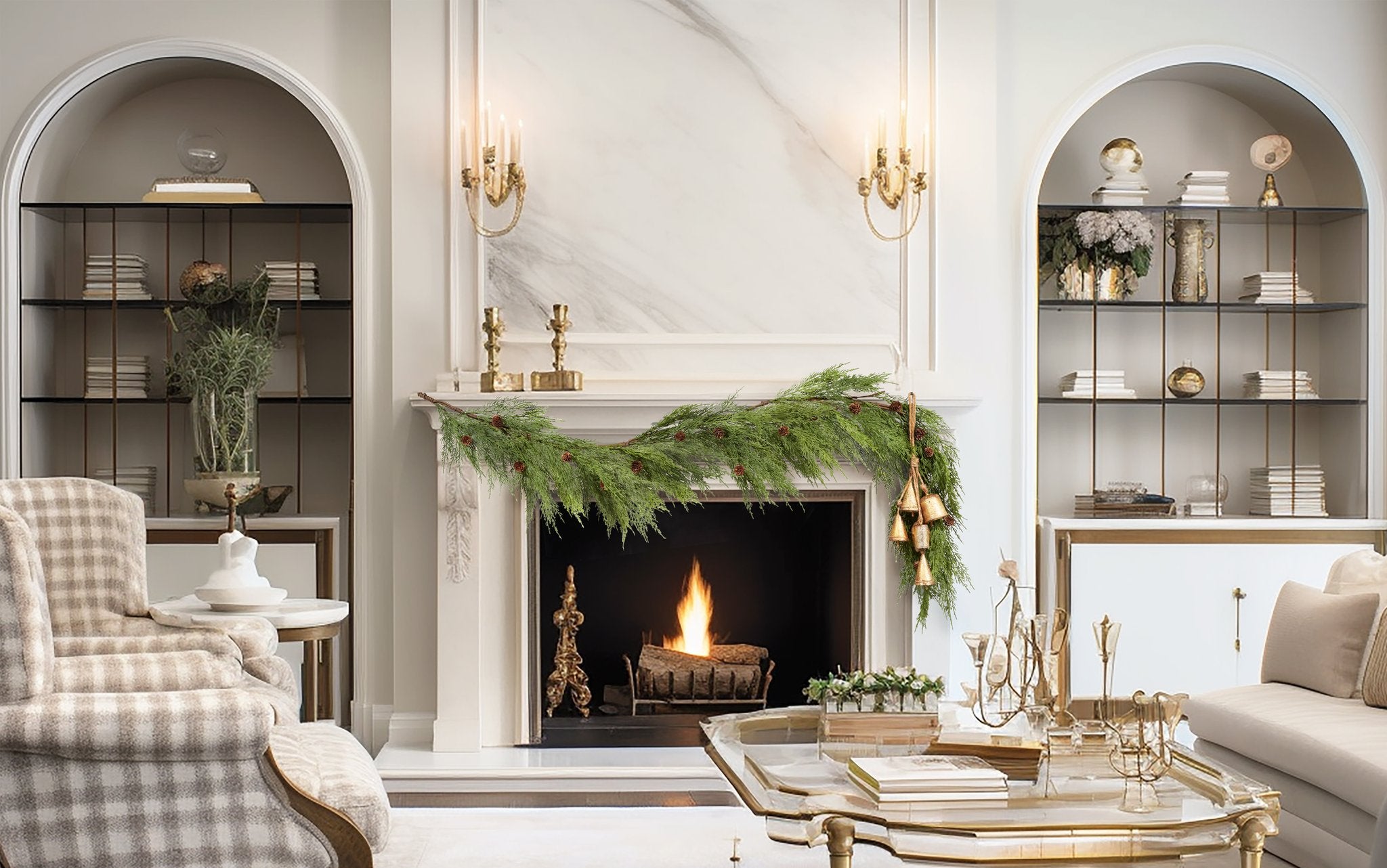 Christmas garland with pine cones and bells draped over a fireplace with a fire burning