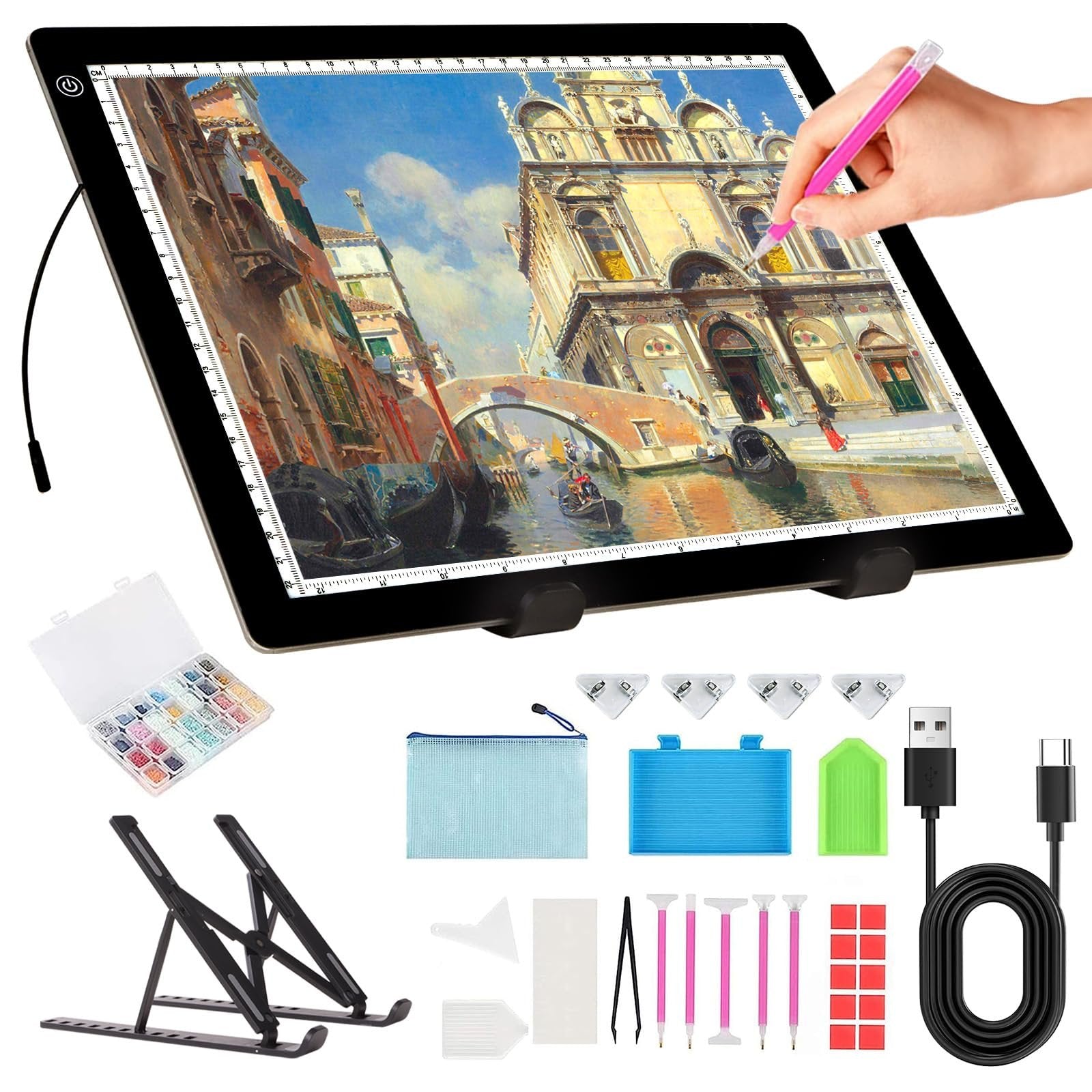 A4 LED light pad with stand, diamond painting kit, and accessories laid out on a white background. A hand is shown using a pink stylus on the light pad.