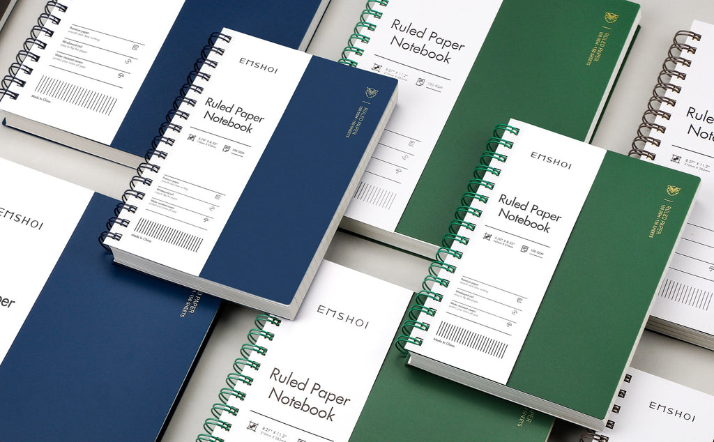 Several spiral-bound notebooks in green and navy blue, some open to show ruled paper and features.