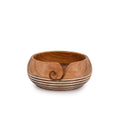 Wooden yarn bowl with carved swirl and striped pattern, shown from a front-side angle on a white background.
