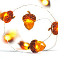Acorn-shaped string lights with warm LED bulbs on a thin wire, close-up view