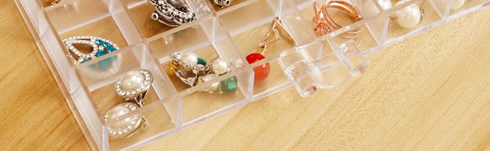 Clear acrylic jewelry organizer with 120 compartments filled with earrings and rings, angled view.