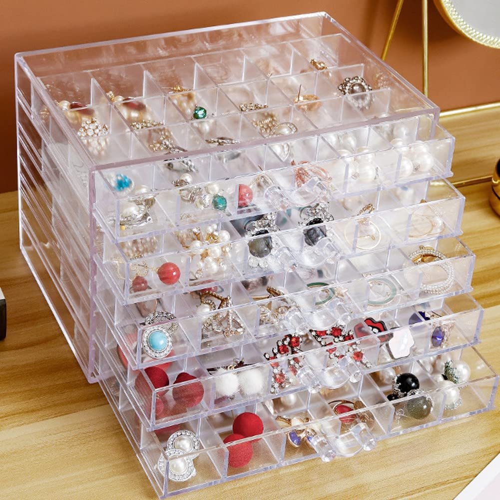 Clear acrylic jewelry organizer with 5 drawers and 120 compartments filled with various rings, earrings, and necklaces.