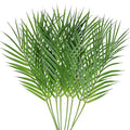 Artificial areca palm leaves fanned out against a white background, showing multiple green fronds and stems.