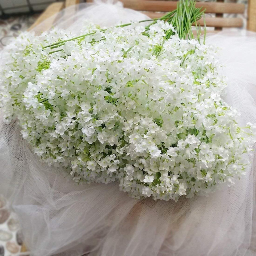 Bouquet of 30 white artificial baby's breath flowers with green stems, laid on white tulle fabric.