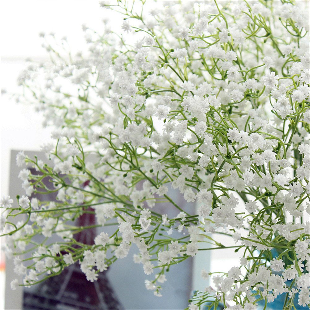 Close-up of a bouquet of artificial white baby's breath flowers with green stems, soft focus background.