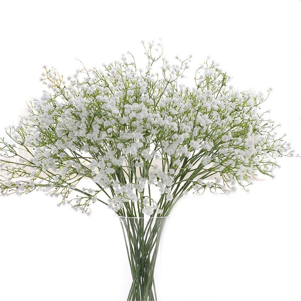 Bunch of artificial white baby's breath flowers in a clear vase against a white background
