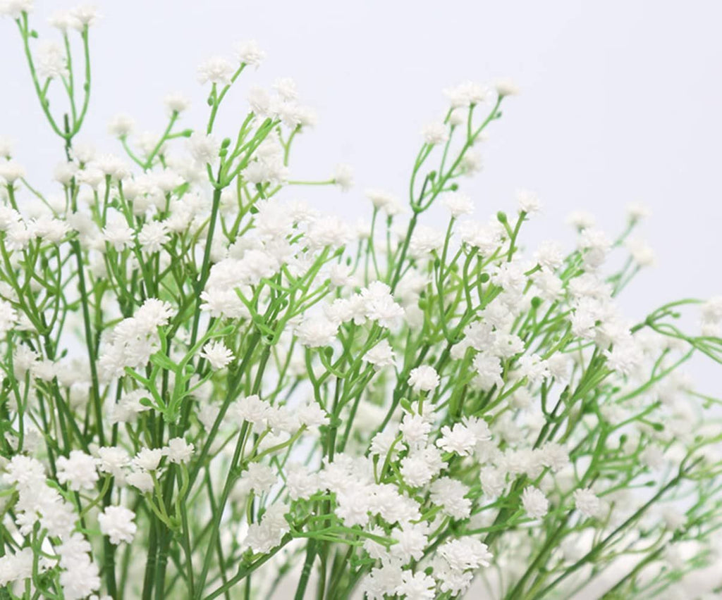 Close-up of artificial white baby's breath flowers with green stems against a white background.