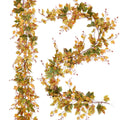Two artificial autumn maple leaf garlands with green, yellow, and orange leaves on white background