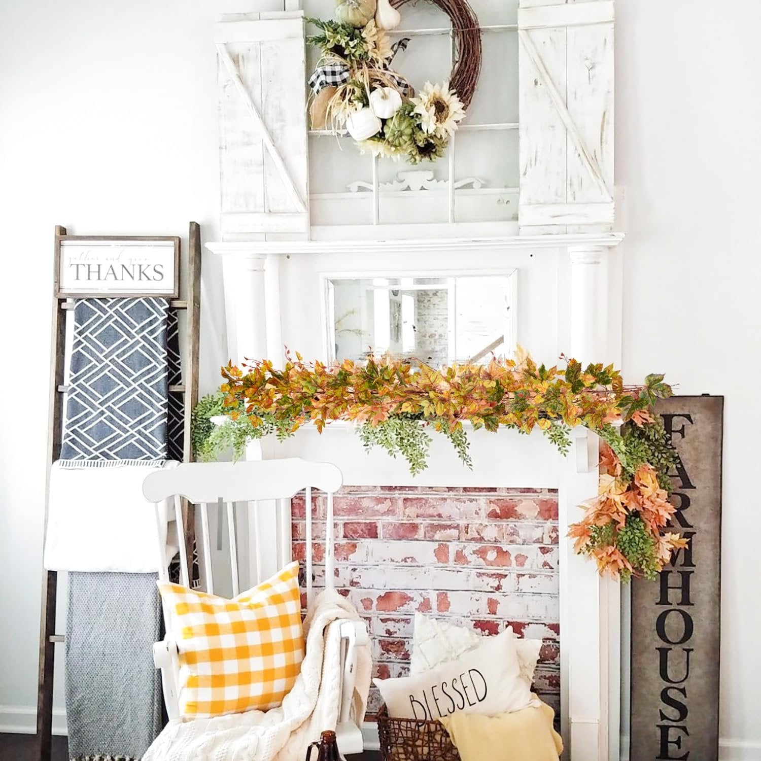 Artificial fall maple leaf garland draped over a fireplace mantel with autumn decor.