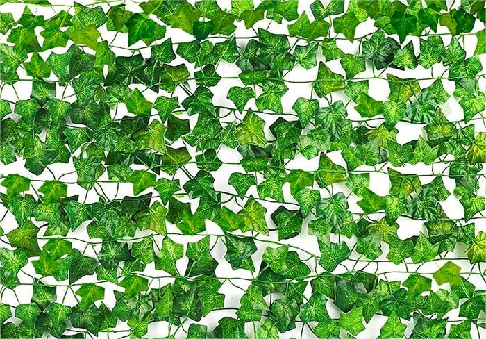 Artificial ivy vines with green silk leaves and plastic stems arranged in a dense pattern against a white background.