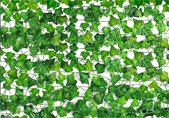 Artificial ivy vines with green silk leaves and plastic stems arranged in a dense pattern against a white background.