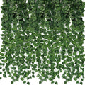Artificial ivy vines with green silk leaves and plastic stems cascading down against a white background.