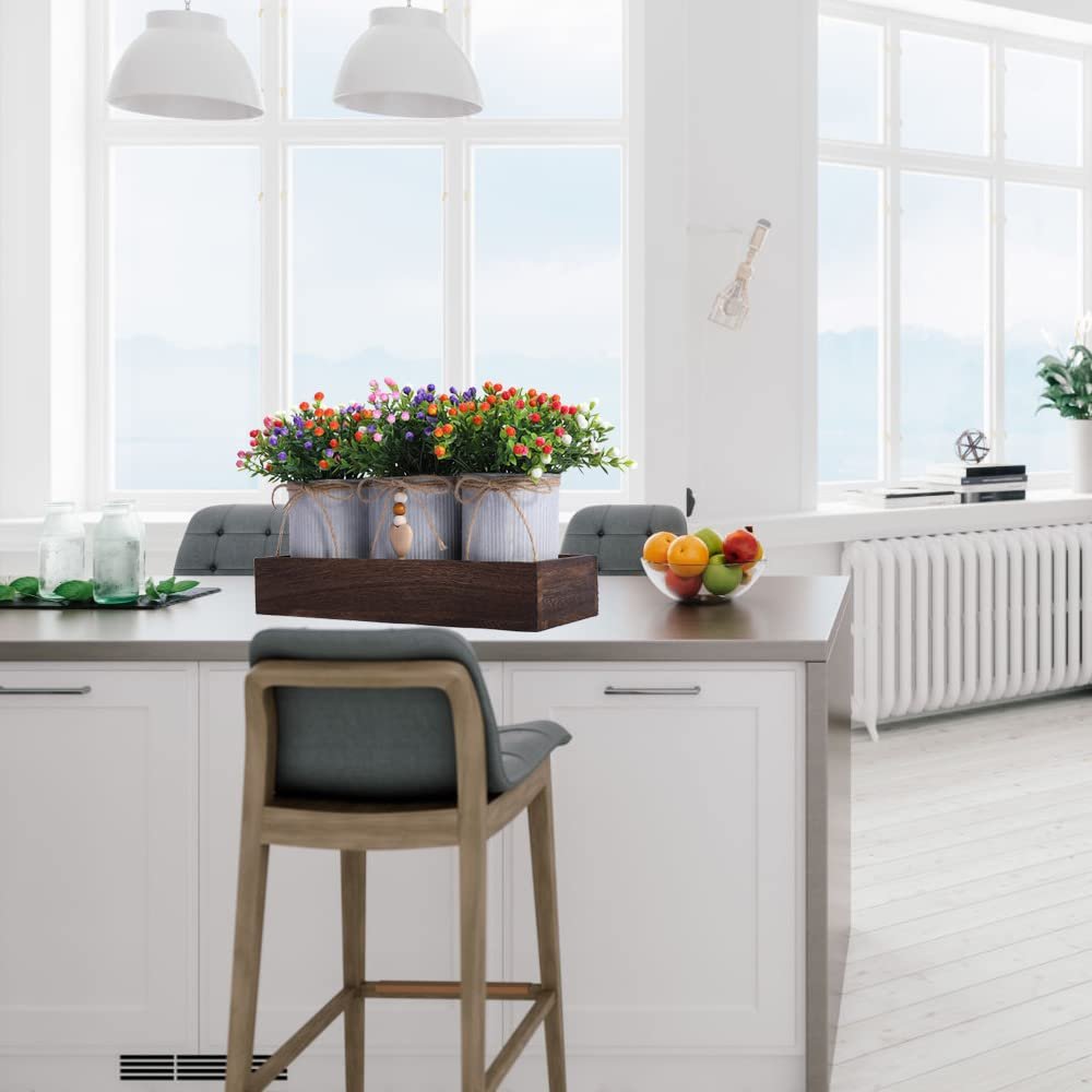 Artificial Milan flower centerpiece set with three metal pots on a wooden tray, displayed on a kitchen island.