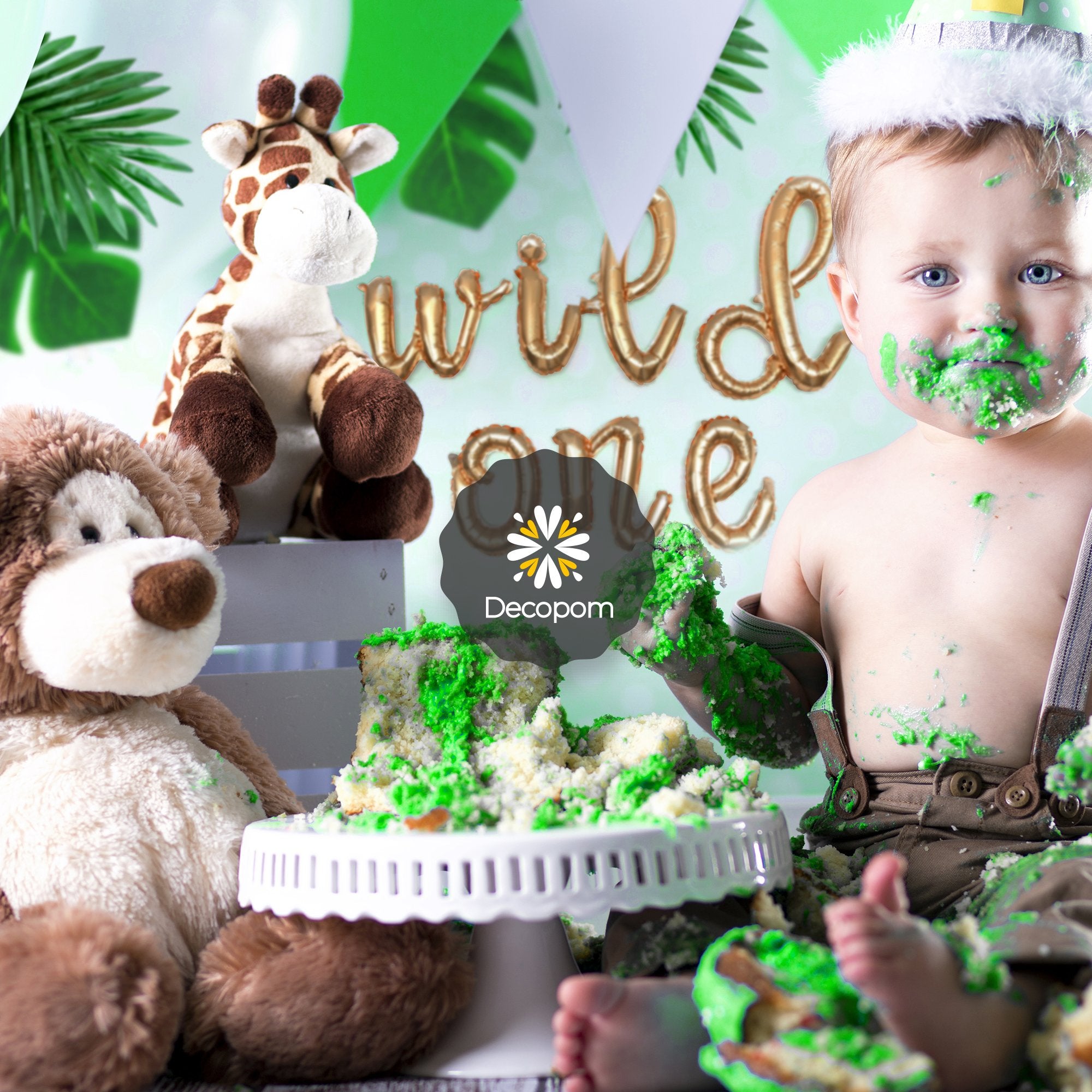 Baby covered in cake with stuffed animals and 'wild one' balloons in background