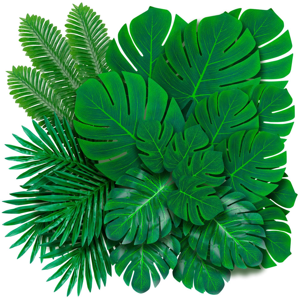 Assortment of artificial palm and monstera leaves in various sizes on a white background