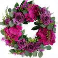 Artificial purple rose and hydrangea wreath with eucalyptus leaves on a white background