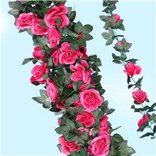 Two artificial rose vine garlands with pink silk flowers and green leaves against a light blue background.