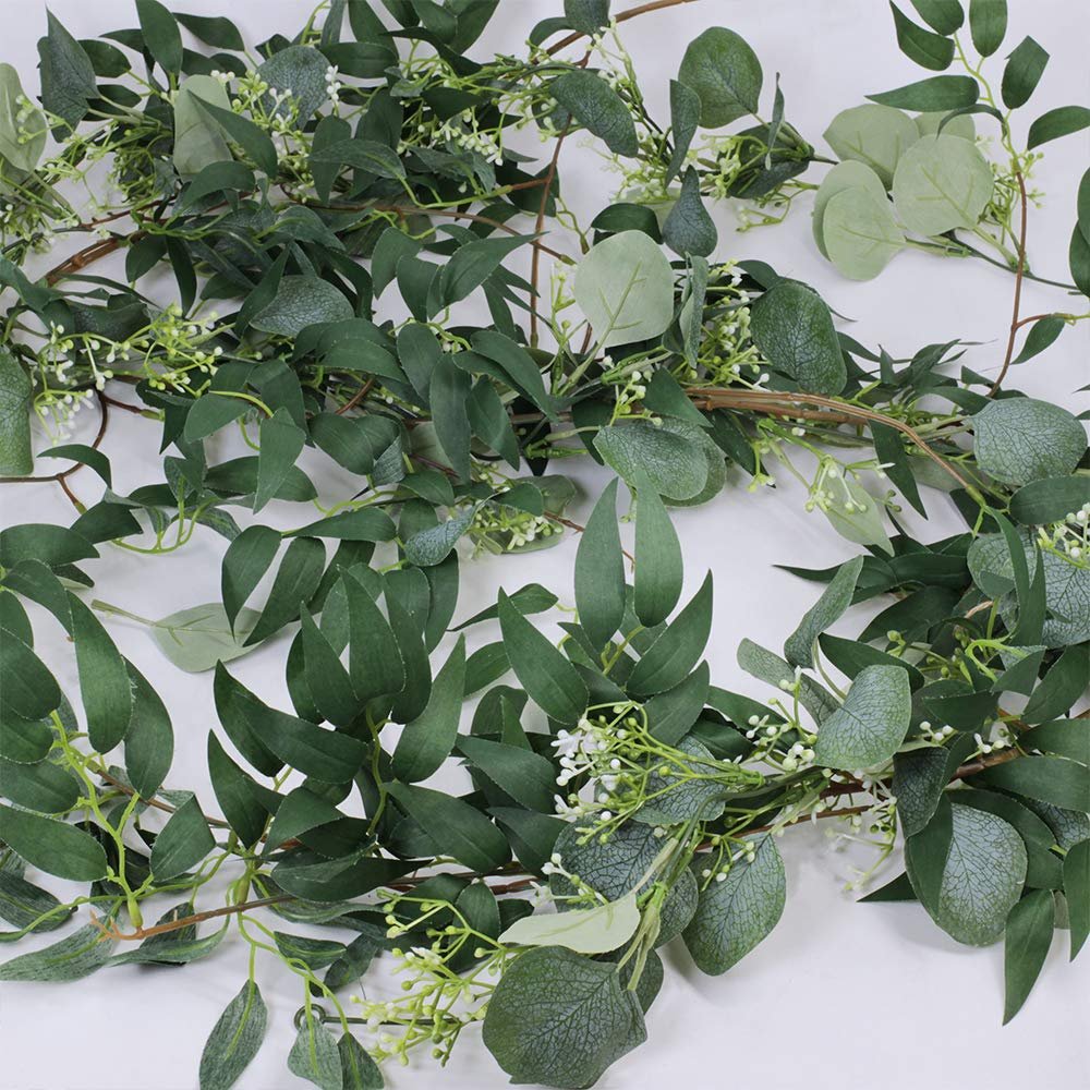 Artificial silver dollar eucalyptus and willow twig garland with small white flowers on a white background.
