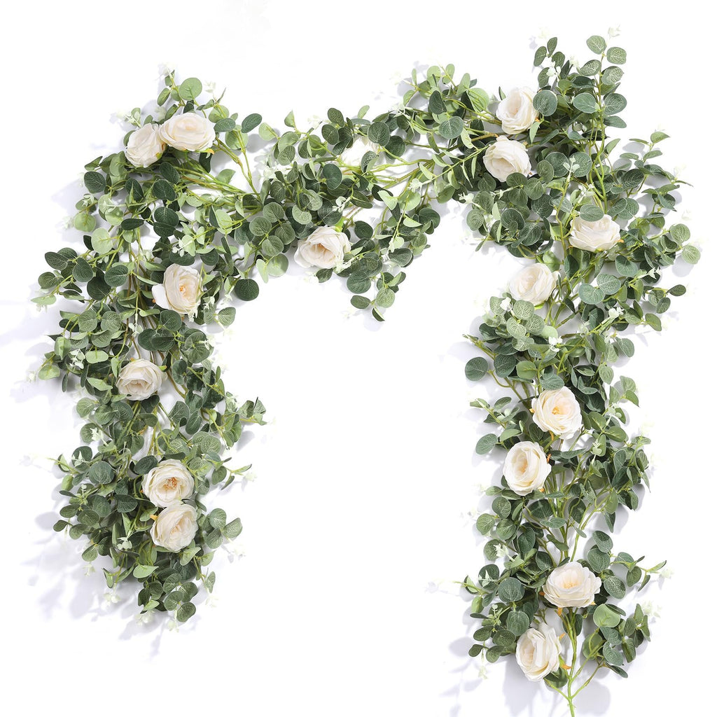 Artificial white rose and eucalyptus garland draped on a white background