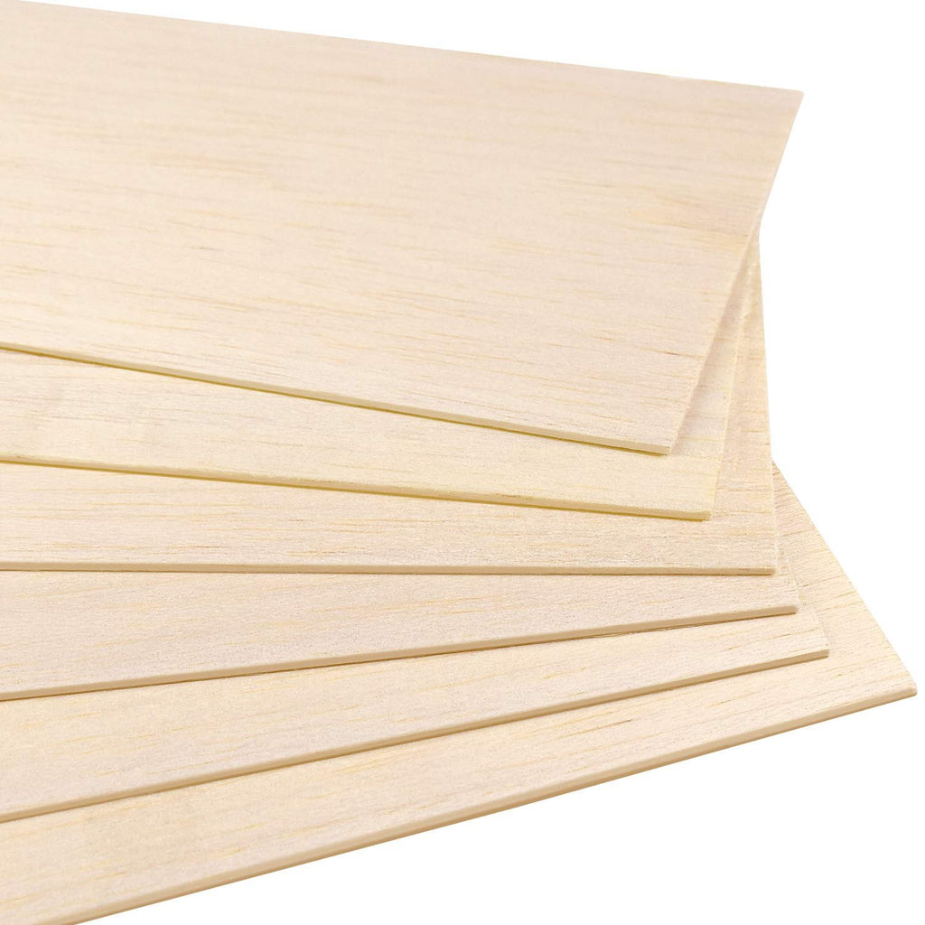 Stack of unfinished natural balsa wood sheets, close-up view showing wood grain and edges.
