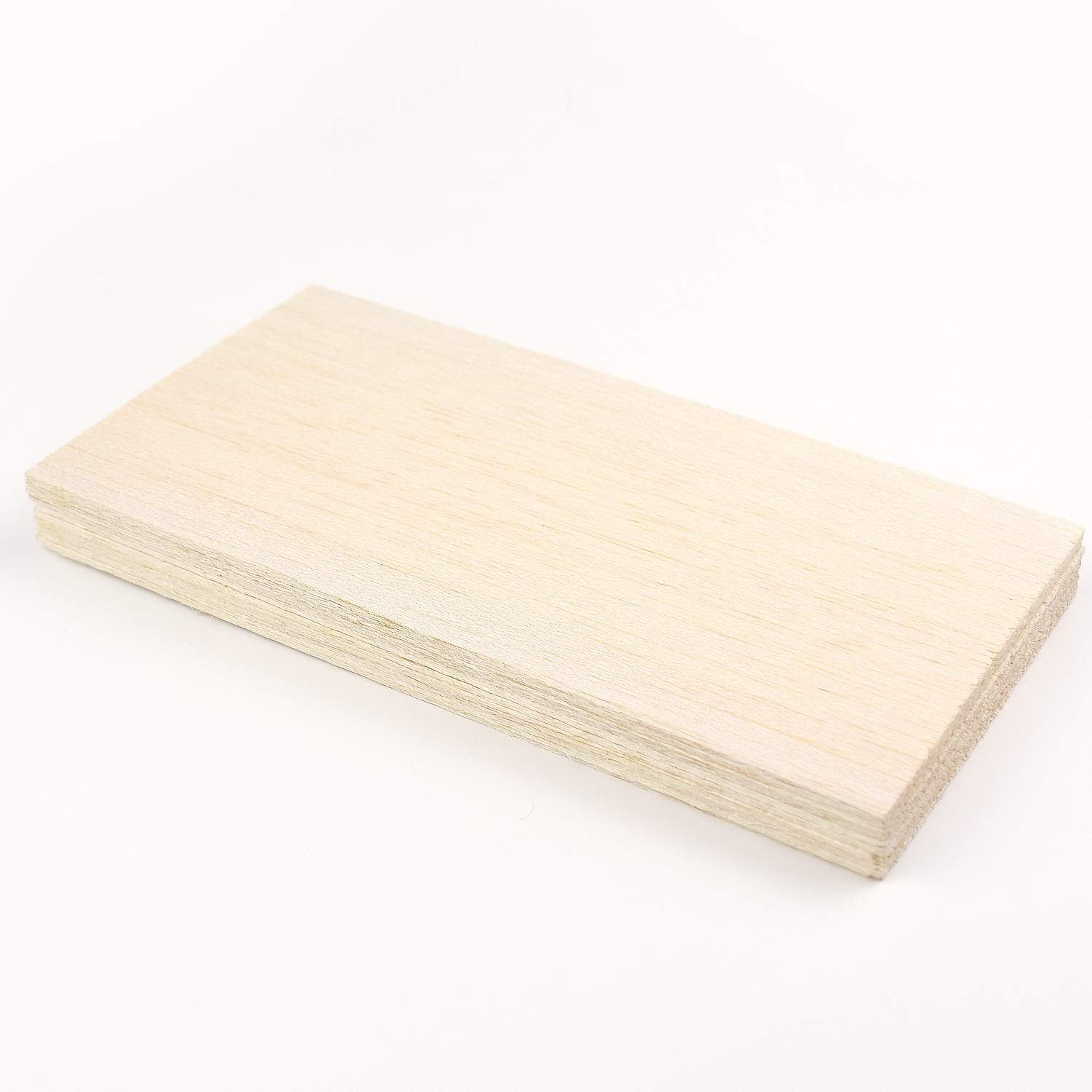 Stack of unfinished balsa wood sheets on a white background, viewed from a slight angle.
