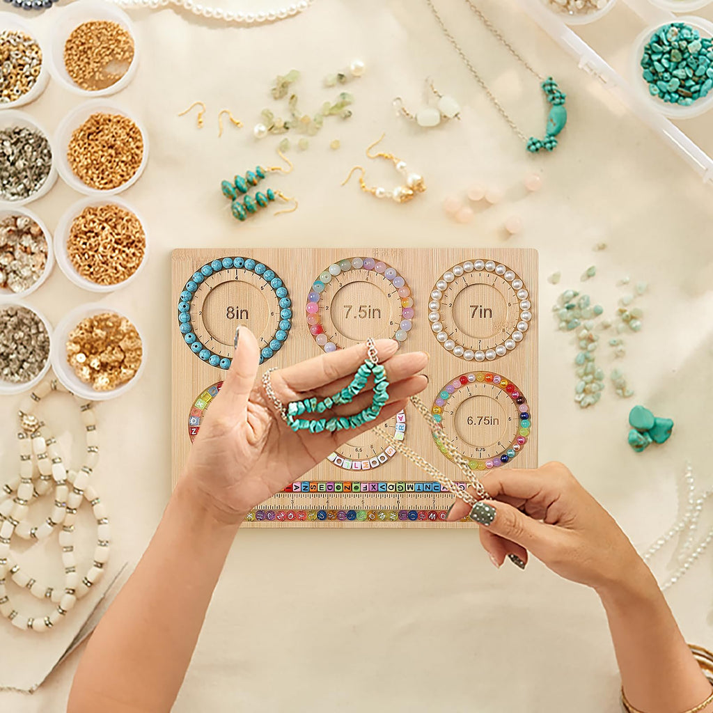 Hands holding jewelry making bead board with bracelet sizing grooves and ruler, surrounded by beads and findings.