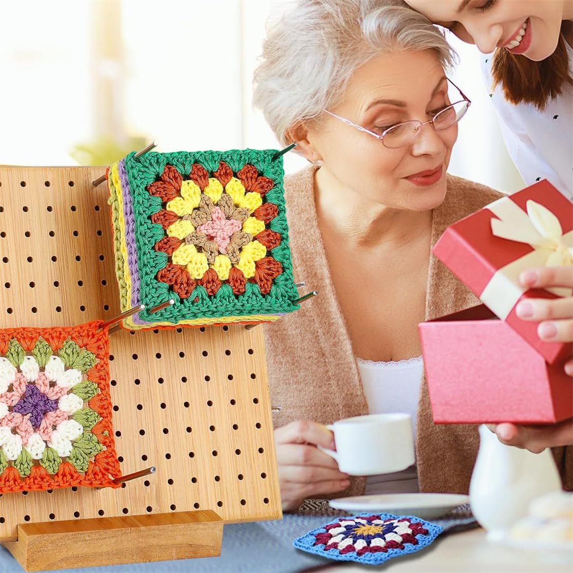 Bamboo crochet blocking board with colorful granny squares and two women opening a gift.