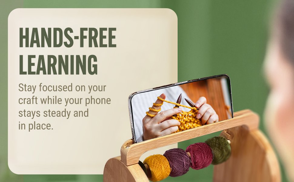 Bamboo yarn organizer with phone stand displaying knitting tutorial, holding colorful yarn balls.