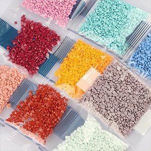 Diamond painting kit gems in individual clear plastic bags, arranged in rows with various colors including pink, red, orange, green, blue, and purple.