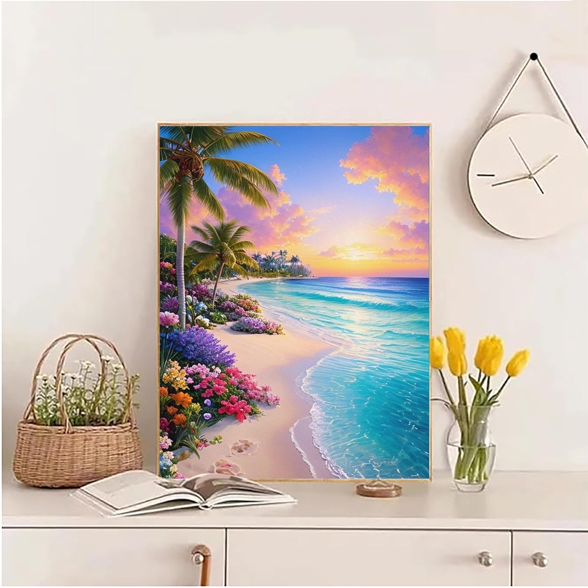 Diamond art kit painting of a tropical beach sunset with palm trees and flowers, displayed on a shelf with decor.