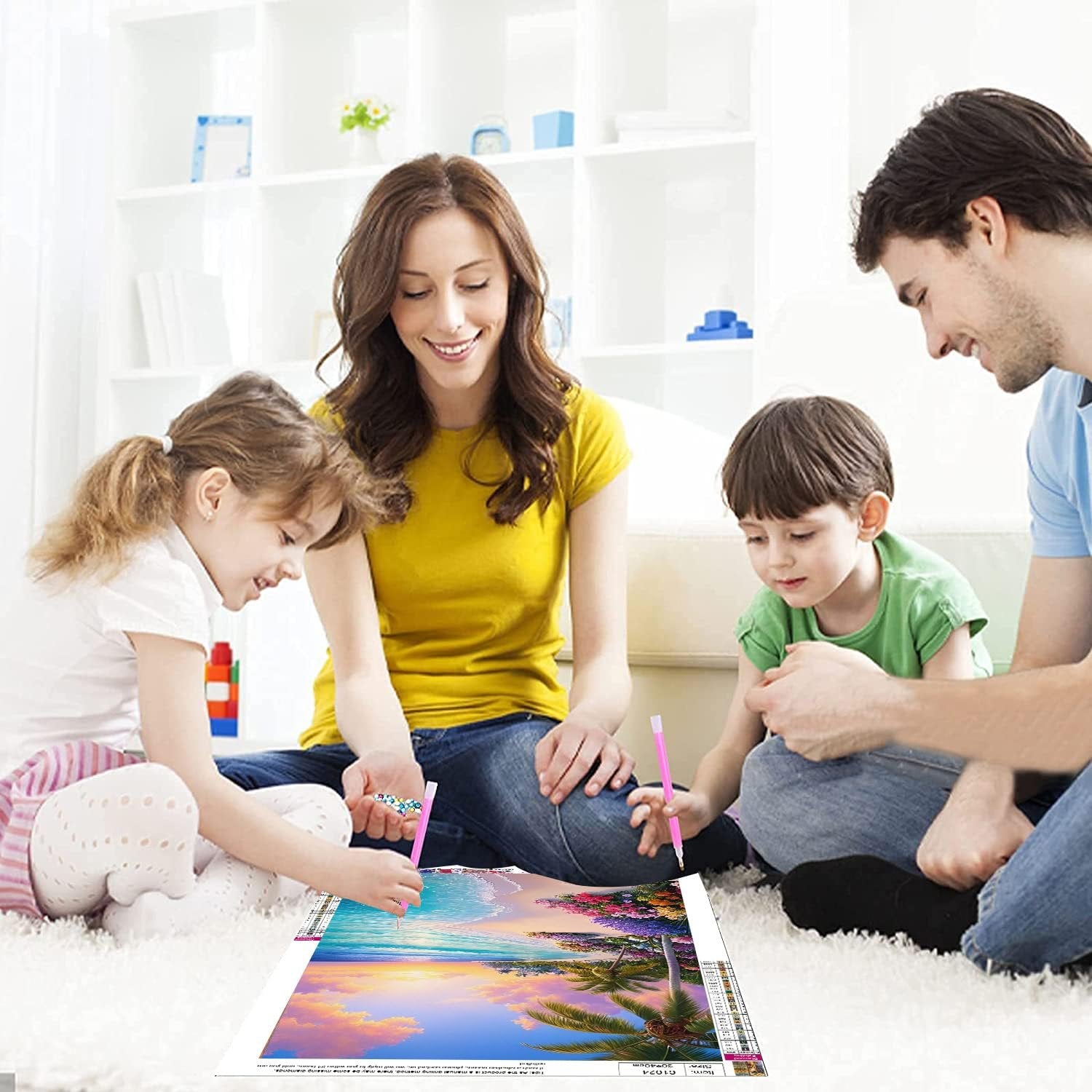Family doing a beach sunset diamond art kit together on the floor