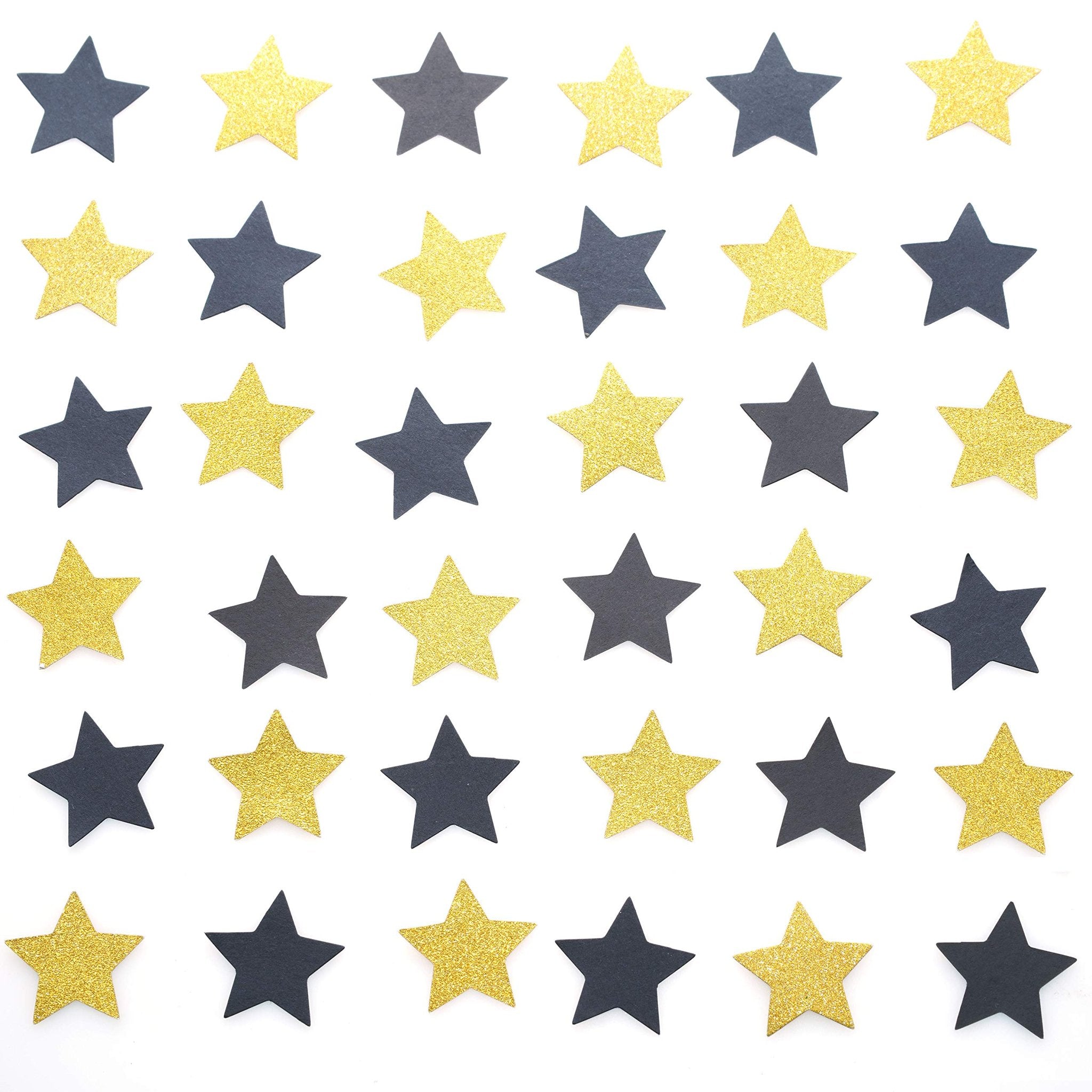 Black and gold glitter star confetti scattered on a white background, top-down view.
