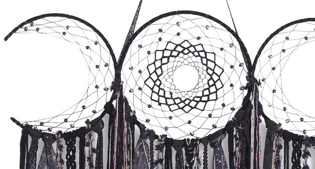 Black triple moon macrame wall hanging with intricate web detail and mixed textile fringe, close-up view.