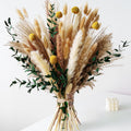 Boho dried flower bouquet with pampas grass, bunny tails, eucalyptus, and craspedia, tied with twine.