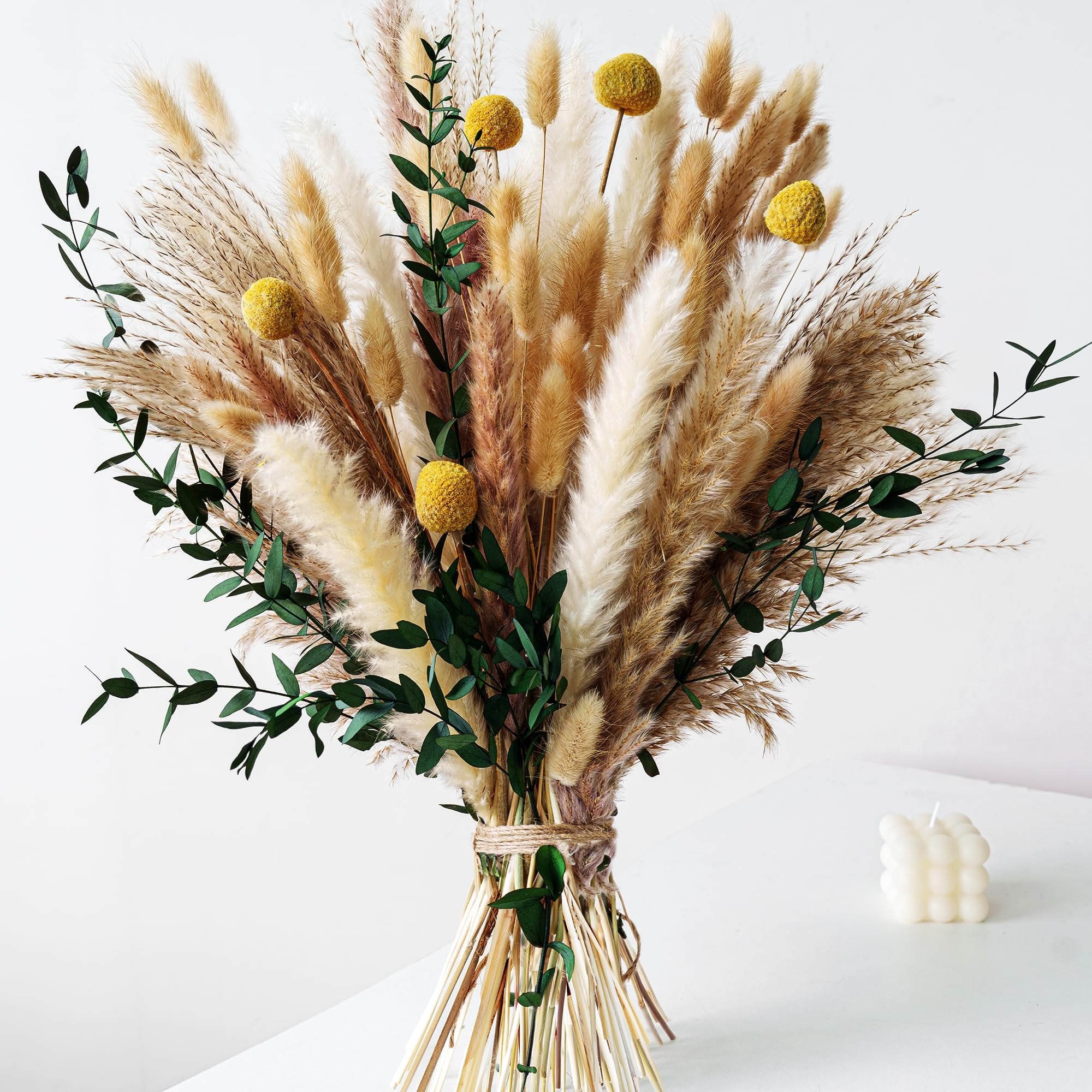 Boho dried flower bouquet with pampas grass, bunny tails, eucalyptus, and craspedia, tied with twine.