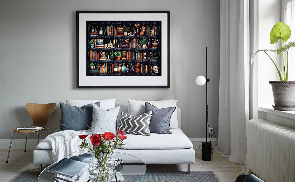 Framed cross stitch art of a bookshelf filled with books, potions, and skulls, displayed above a sofa in a living room.