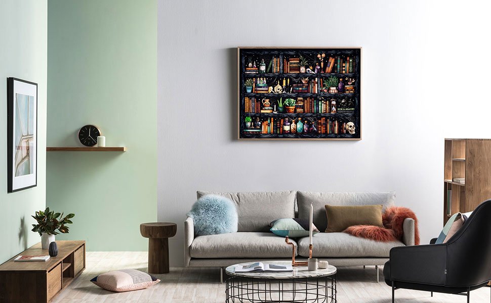 Framed cross stitch art of a bookshelf with books, potions, and a skull, displayed on a living room wall above a sofa.