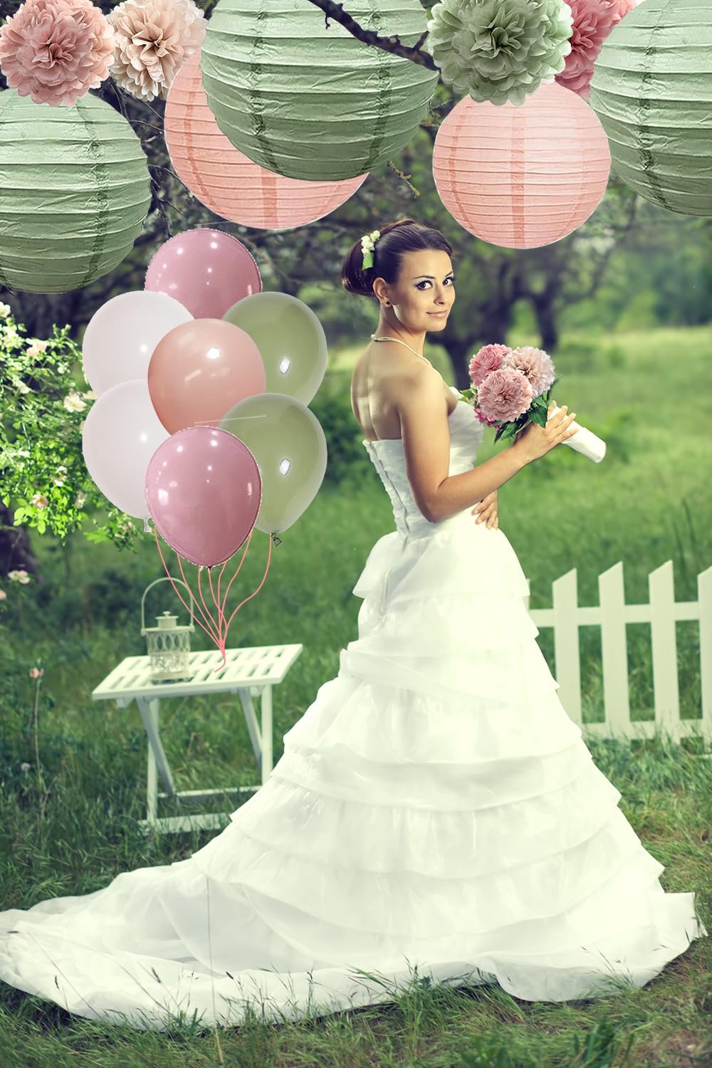 Bride in a white gown holding a bouquet, with sage green and rose pink balloons and paper lanterns arranged around her in a garden setting.