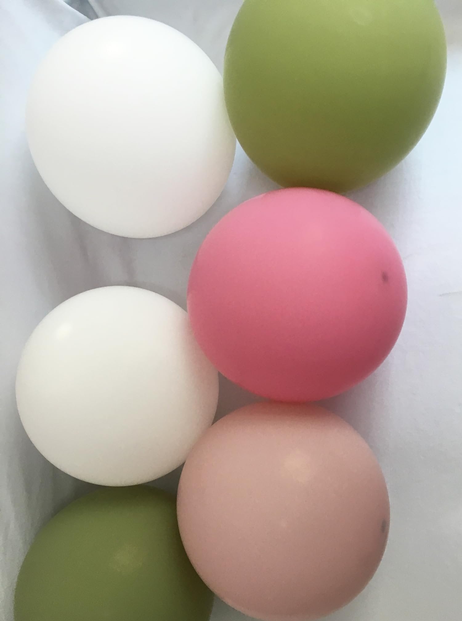 Assortment of round balloons in white, sage green, rose pink, and blush pink, arranged vertically.