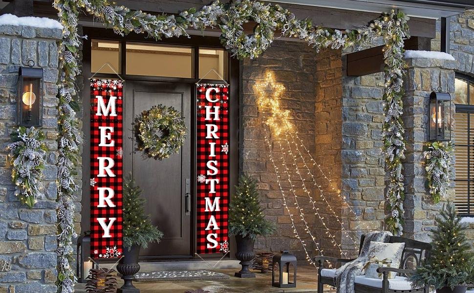 Two buffalo plaid porch banners reading Merry Christmas hang on a front door, flanked by holiday decorations.