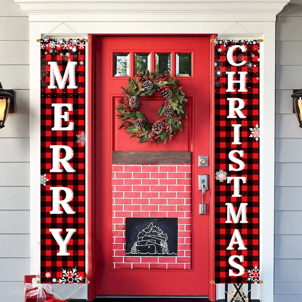 Two red and black buffalo plaid Christmas porch banners flanking a red door with a wreath and faux fireplace decoration.